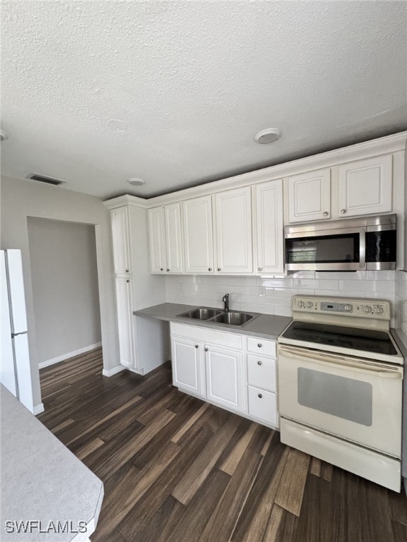 kitchen with white appliances, dark wood-type flooring, white cabinets, sink, and decorative backsplash