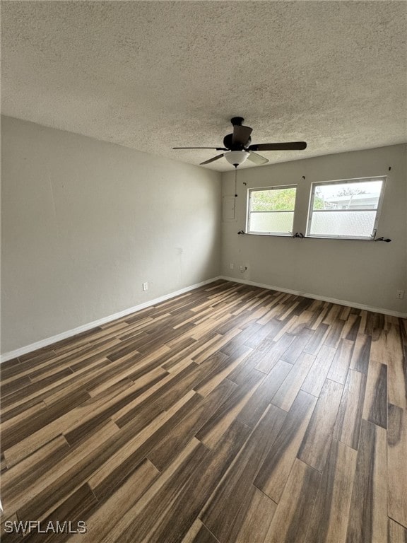 spare room featuring ceiling fan, dark hardwood / wood-style flooring, and a textured ceiling