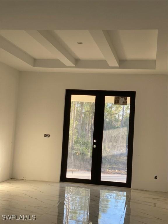 doorway to outside with plenty of natural light, beam ceiling, and french doors