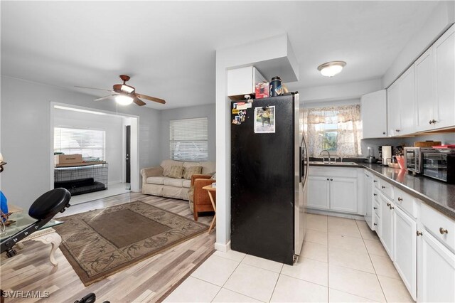 kitchen with ceiling fan, sink, stainless steel appliances, light hardwood / wood-style floors, and white cabinets