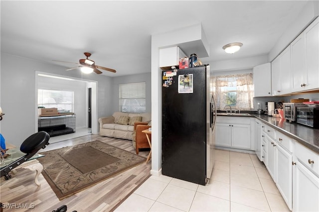 kitchen featuring sink, light tile patterned floors, ceiling fan, appliances with stainless steel finishes, and white cabinetry