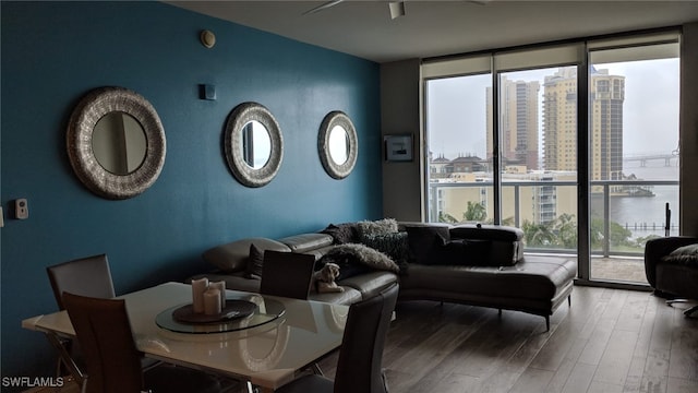 living room with hardwood / wood-style flooring, expansive windows, and a water view