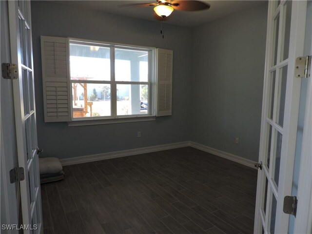 empty room with ceiling fan and dark hardwood / wood-style flooring