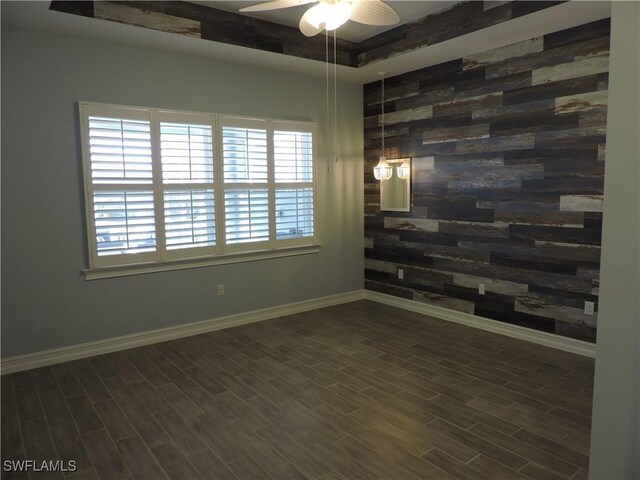 empty room with ceiling fan and dark wood-type flooring