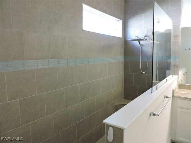 bathroom featuring vanity and a tile shower