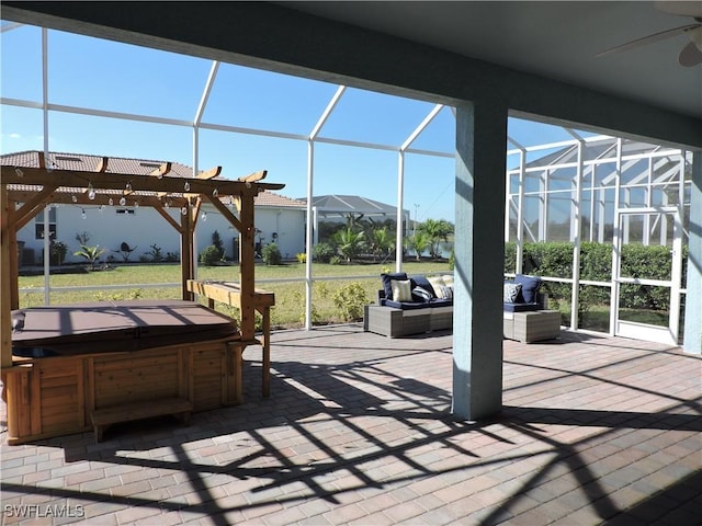 view of patio with an outdoor living space, glass enclosure, a hot tub, and ceiling fan