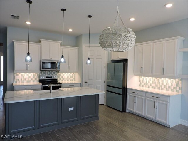 kitchen featuring pendant lighting, white cabinetry, a center island with sink, and stainless steel appliances