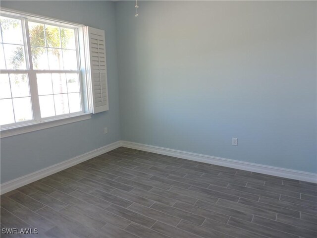 unfurnished room with dark wood-type flooring