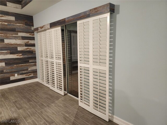 interior space with wood walls and dark wood-type flooring