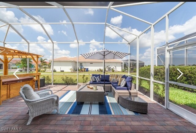 view of patio with outdoor lounge area, glass enclosure, and a hot tub