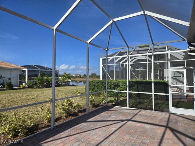 unfurnished sunroom with a water view and a swimming pool