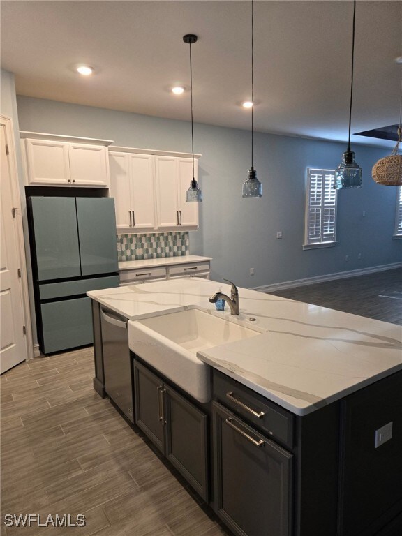 kitchen with decorative backsplash, refrigerator, pendant lighting, dishwasher, and white cabinetry