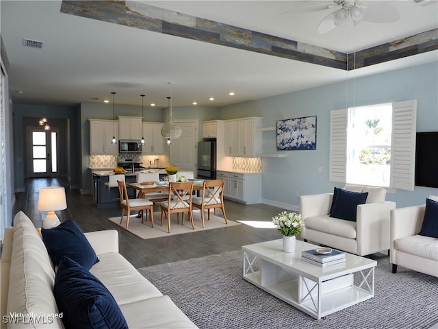 living room with ceiling fan and dark hardwood / wood-style flooring