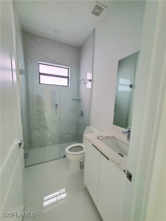 bathroom featuring tile patterned flooring, vanity, toilet, and a shower with door