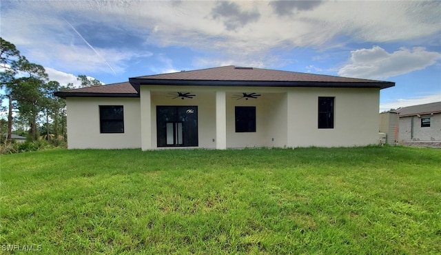 back of property featuring a lawn and ceiling fan