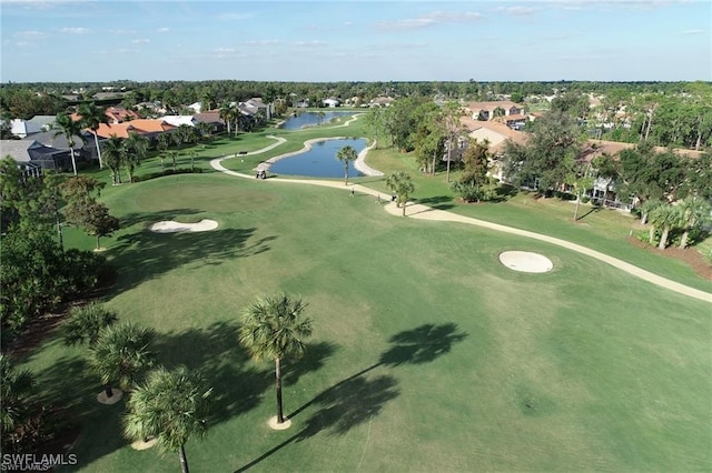 birds eye view of property with golf course view and a water view