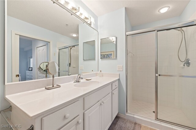 bathroom featuring tile patterned floors, vanity, and walk in shower