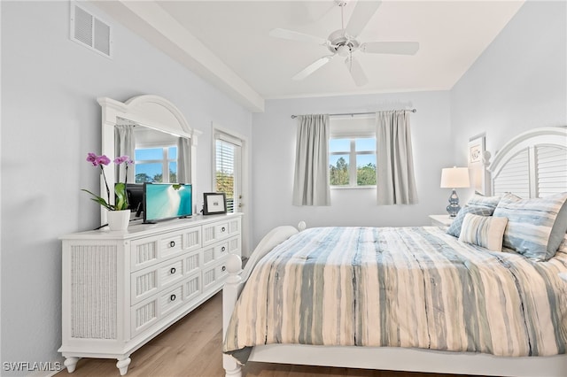 bedroom with wood finished floors, ceiling fan, and visible vents