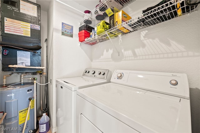 clothes washing area with water heater, washer and clothes dryer, and laundry area