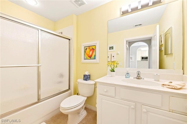 full bathroom featuring combined bath / shower with glass door, vanity, tile patterned floors, and toilet