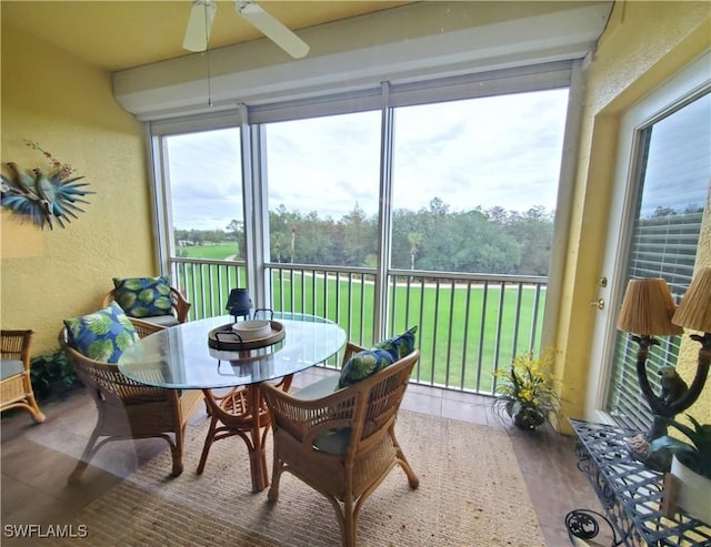 sunroom / solarium with plenty of natural light, ceiling fan, and a textured wall