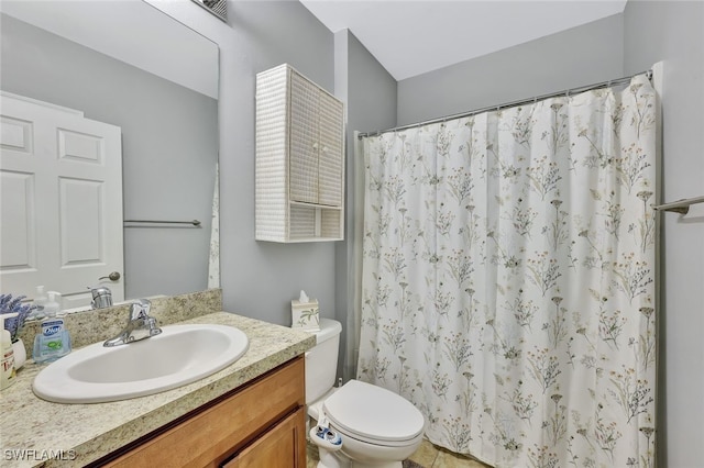 bathroom featuring tile patterned floors, walk in shower, vanity, and toilet