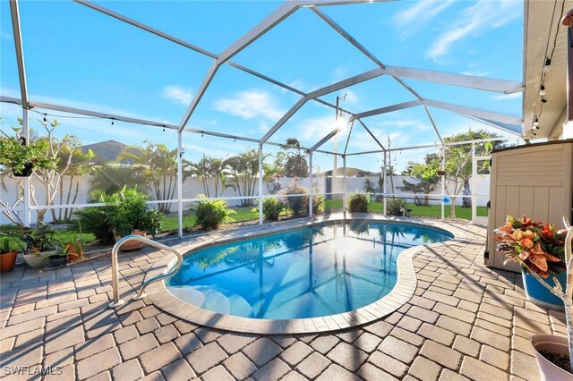 view of swimming pool with glass enclosure and a patio