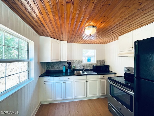 kitchen with tasteful backsplash, light hardwood / wood-style flooring, stainless steel electric stove, black refrigerator, and white cabinets