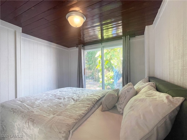 bedroom with wood walls and wooden ceiling