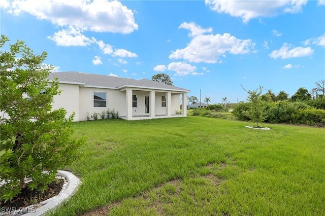 rear view of property featuring a yard