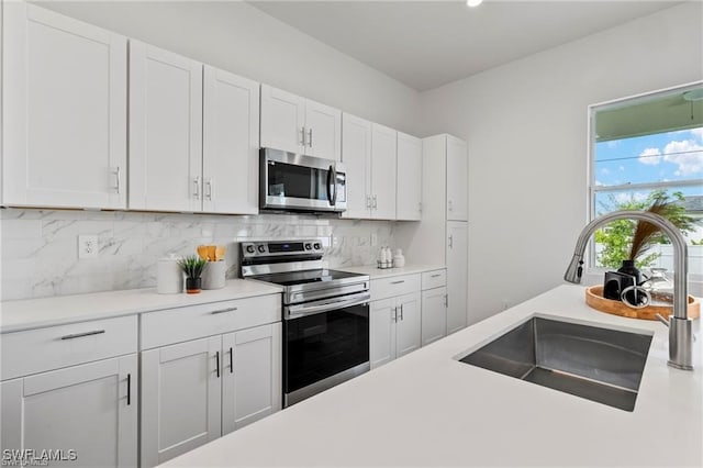 kitchen with white cabinets, stainless steel appliances, and sink