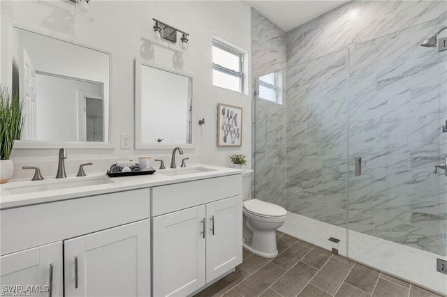 bathroom featuring vanity, toilet, and a shower with shower door