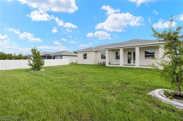 back of property featuring a lawn and french doors