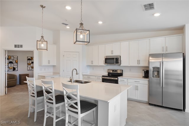 kitchen with sink, stainless steel appliances, vaulted ceiling, a center island with sink, and white cabinets