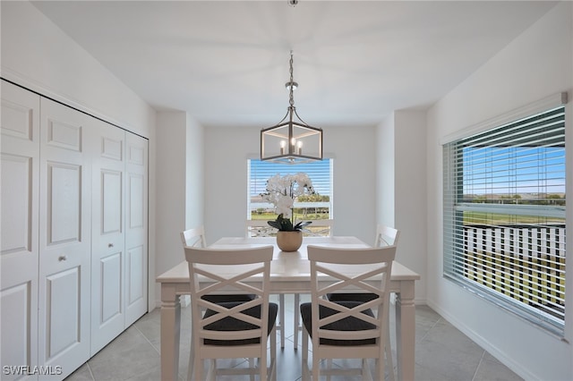 dining area featuring light tile patterned flooring and an inviting chandelier