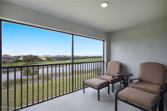 sunroom / solarium featuring a water view