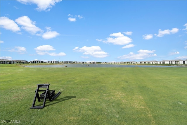 view of property's community featuring a lawn and a water view