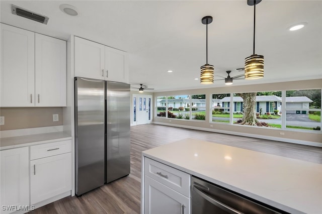 kitchen with appliances with stainless steel finishes, ceiling fan, decorative light fixtures, white cabinets, and dark hardwood / wood-style floors