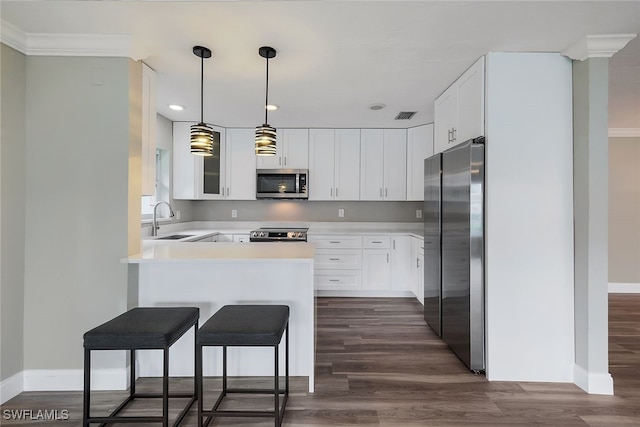 kitchen featuring dark wood-style flooring, visible vents, appliances with stainless steel finishes, a sink, and a peninsula