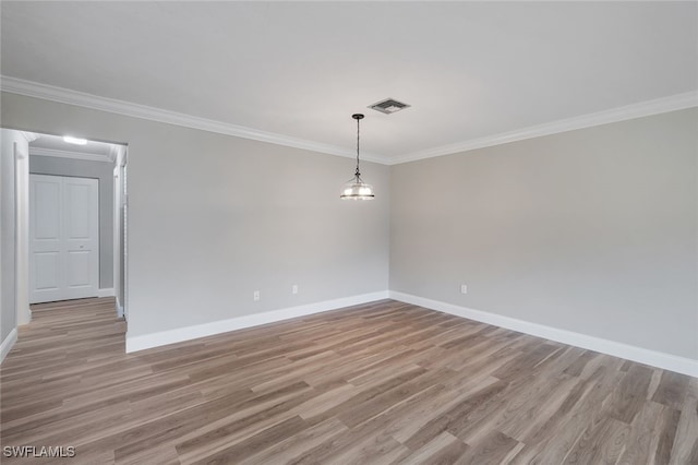 empty room featuring light wood-type flooring and crown molding