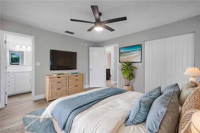 bedroom with ceiling fan, sink, ensuite bathroom, light hardwood / wood-style floors, and a closet