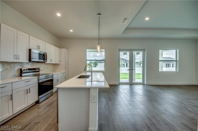 kitchen featuring appliances with stainless steel finishes, dark hardwood / wood-style flooring, white cabinetry, and sink