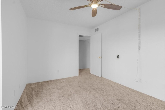 empty room with ceiling fan and light colored carpet