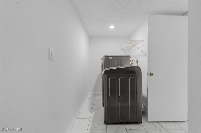 laundry room featuring washer hookup and a textured ceiling