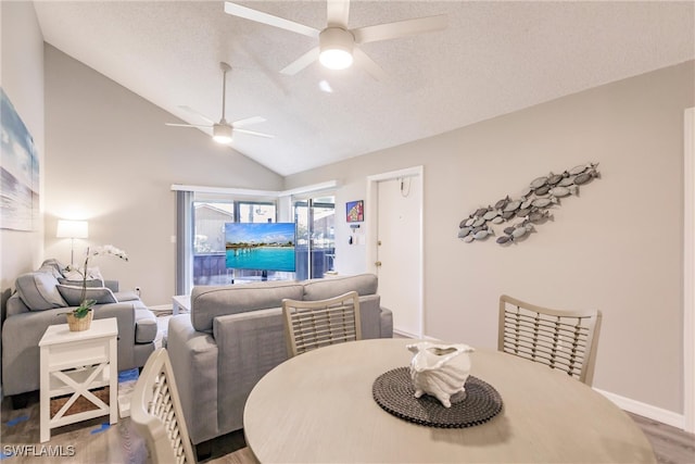 dining area featuring hardwood / wood-style floors, ceiling fan, lofted ceiling, and a textured ceiling