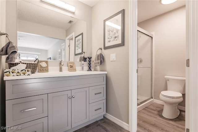 bathroom with a shower with door, vanity, and wood-type flooring