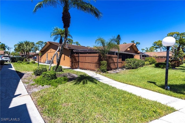 view of front of house with a front lawn and fence