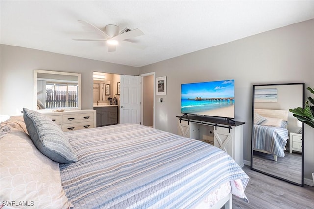 bedroom featuring connected bathroom, baseboards, light wood-type flooring, and ceiling fan