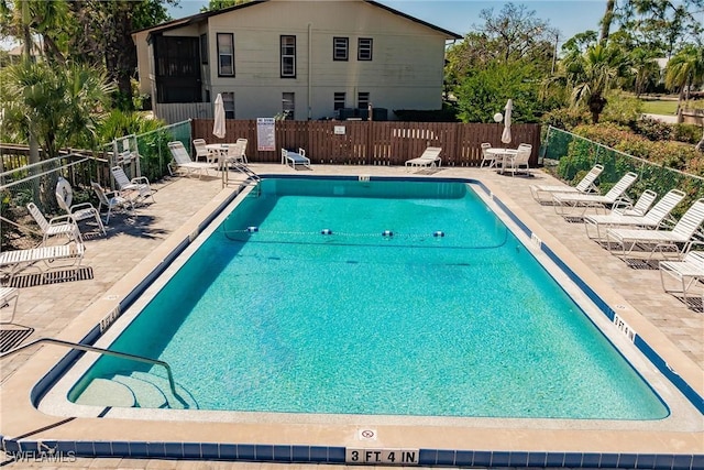 community pool featuring a patio and fence