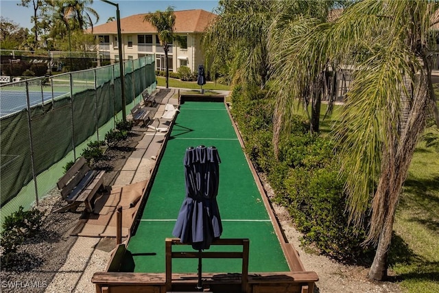 surrounding community featuring a tennis court and fence